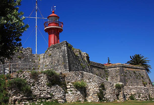 Portugal, Figueira da Foz, Old fortress and lighthouse against a clear blue sky.