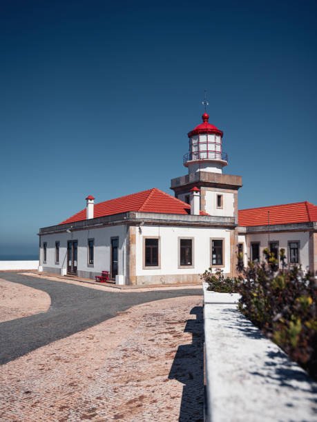 Serra da Boa Viagem, Figueira da Foz, Portugal - July 23, 2022: Farol do Cabo Mondego, vertical photo showing the building and lighthouse red tower against the dark blue sky