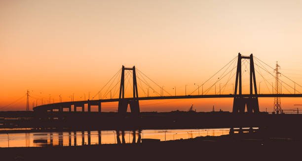 Sunset silhouette of the large suspension concrete bridge near Figueira da Foz, Portugal